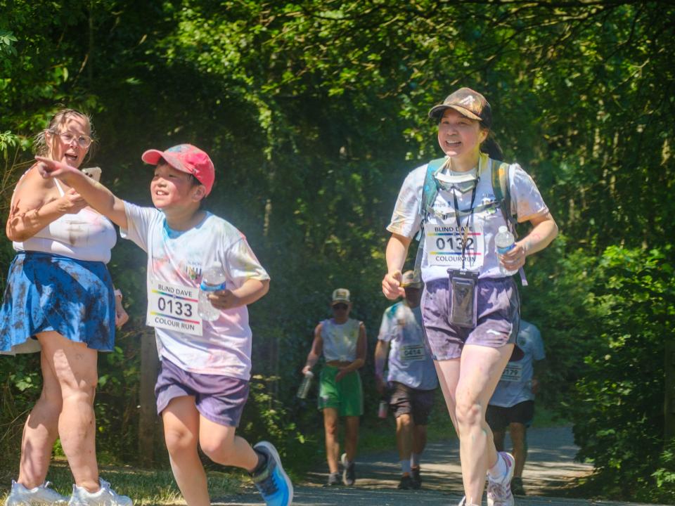 Son and Mother heading to the stretch, as he points towards the finish line.