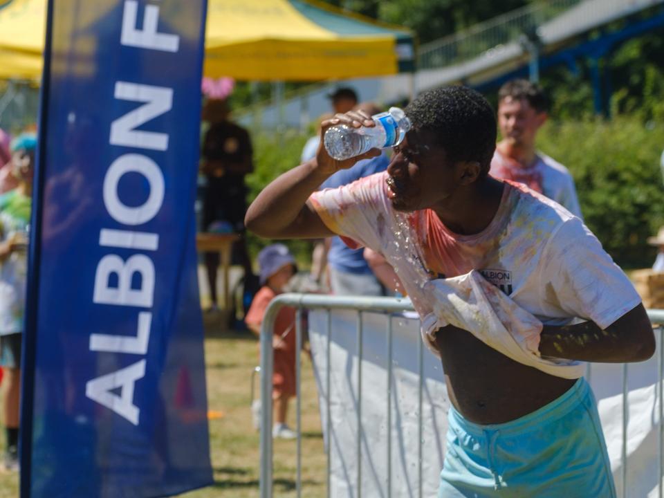 Participant pouring water over his face, after the run.