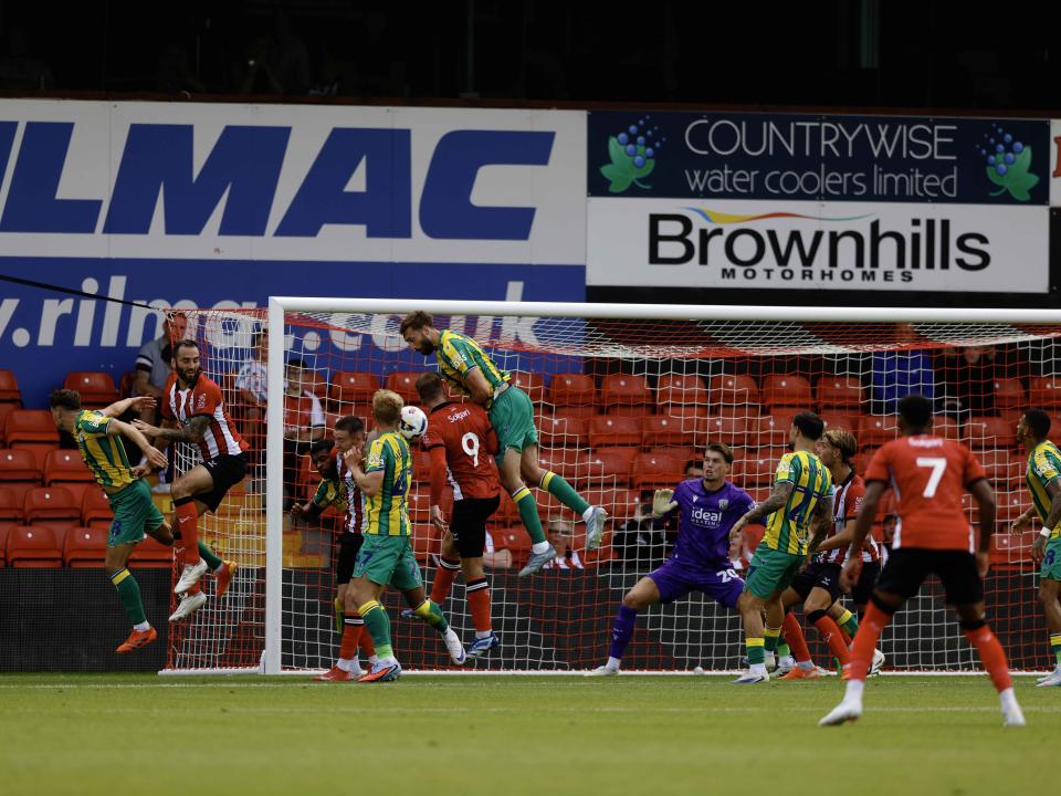 A photo of Nat Phillips in the 2025/26 green and yellow away kit