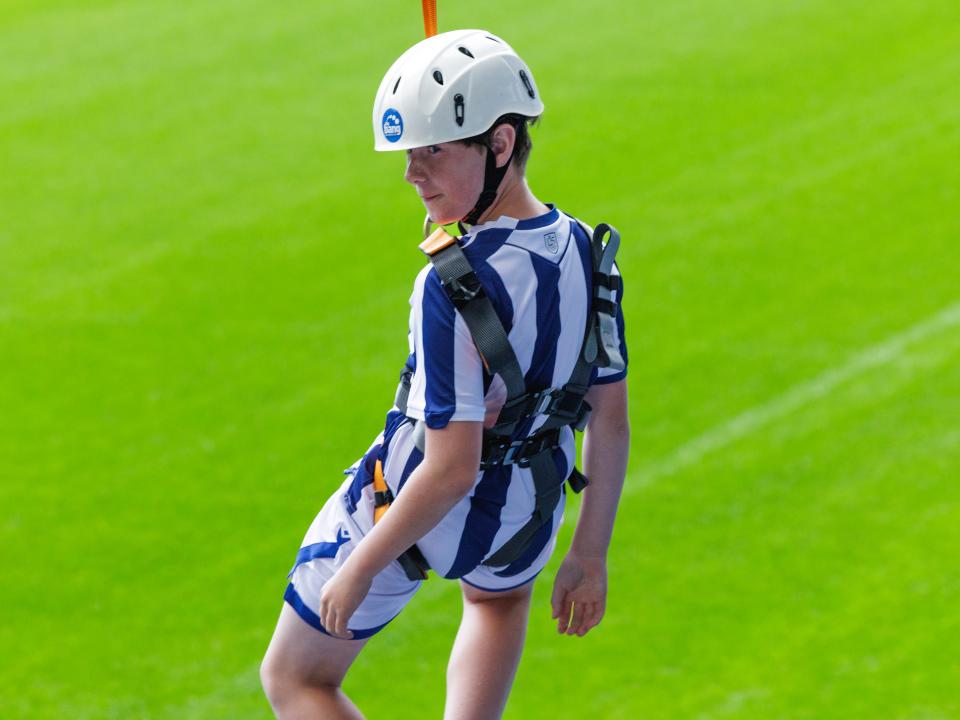 A participant zip wires across The Hawthorns.