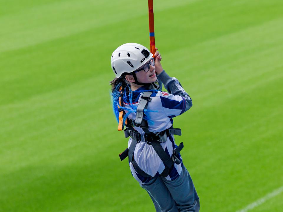 A participant zip wires across The Hawthorns.
