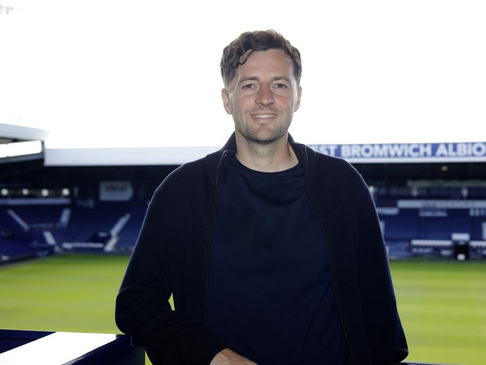 Ryan Mason posing for a photo at The Hawthorns with the West Stand behind him