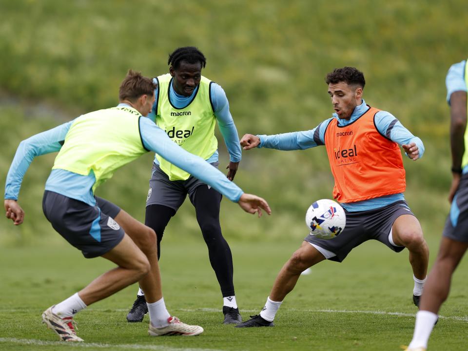 Tammer Bany on the ball during a training session in Austria with two players close by 