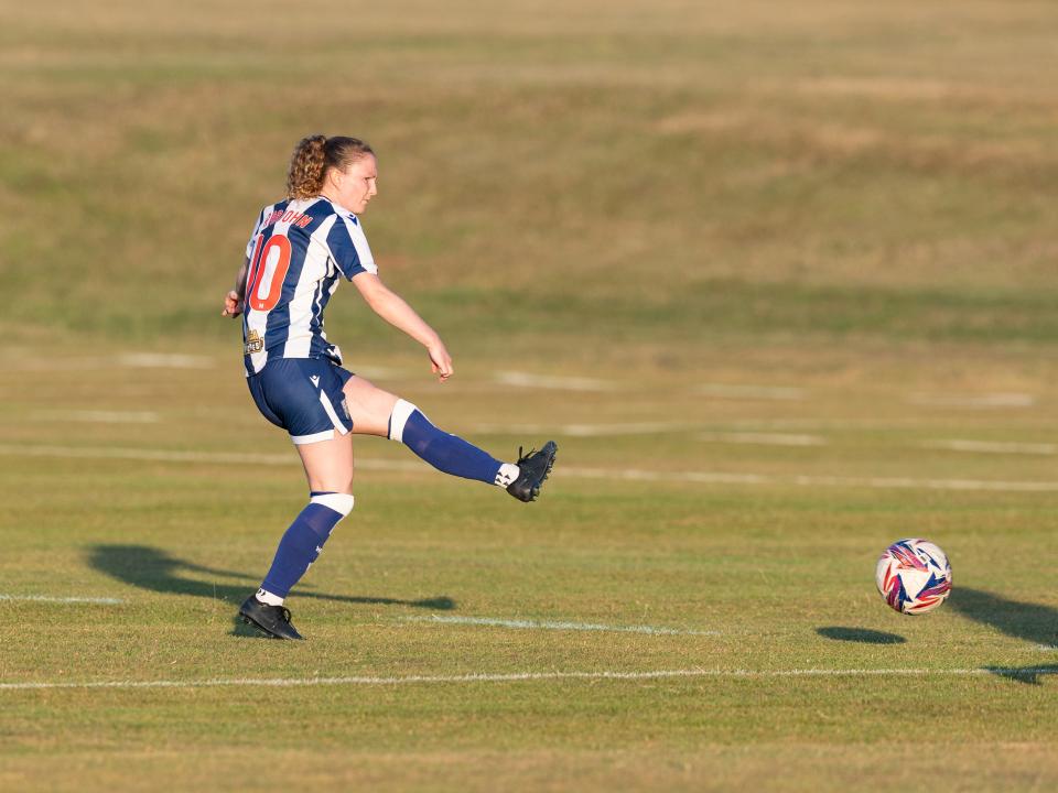 An image of Liv Rabjohn kicking a ball in a pre-season friendly for Albion Women