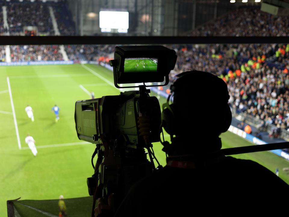 A tv cameraman filming a game from the gantry at The Hawthorns