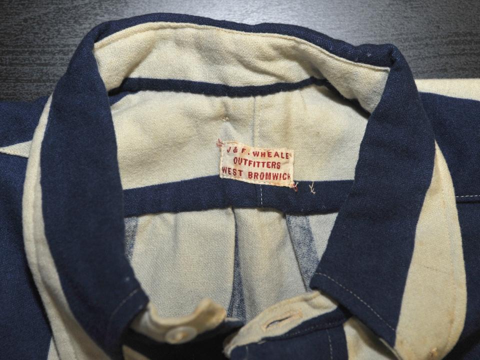 Close up of shirt label featuring J&F Wheale Outfitters West Bromwich 