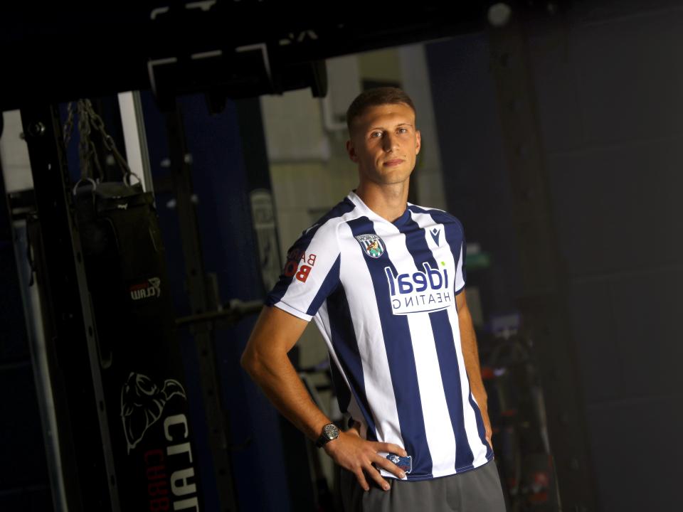 Krystian Bielik in a home shirt in the gym looking at the camera 