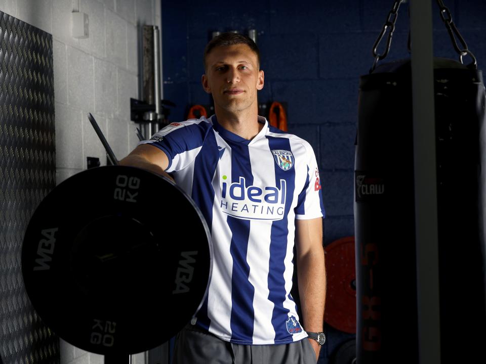 Krystian Bielik in a home shirt in the gym looking at the camera 