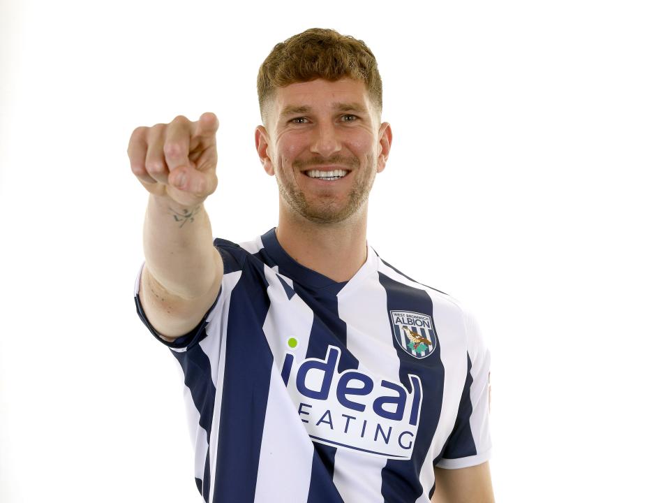 Chris Mepham in the home kit smiling and pointing at the camera 