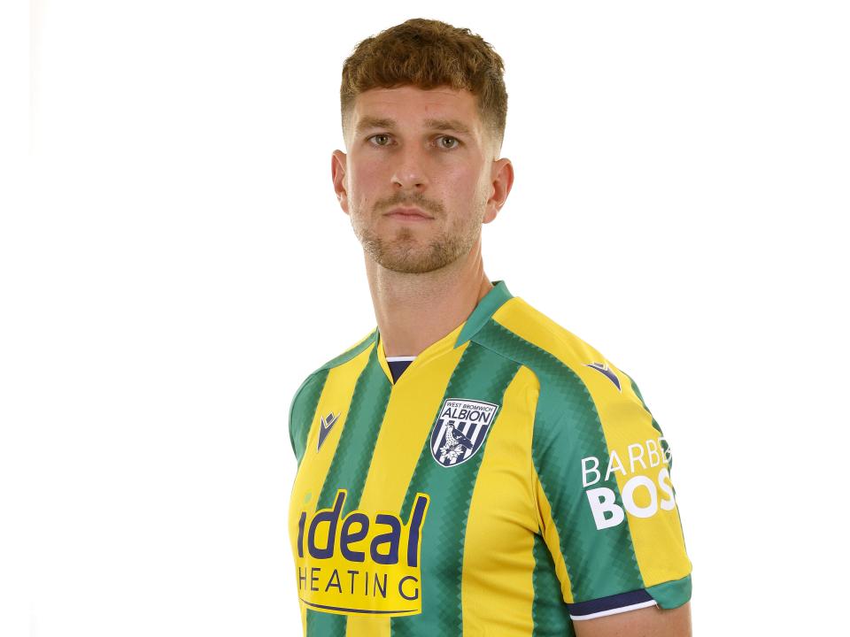 Chris Mepham looking at the camera while stood in the green and yellow away kit 