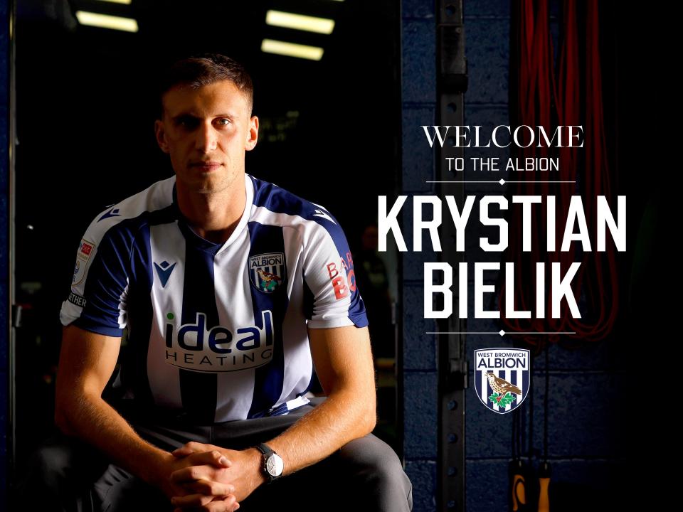 Krystian Bielik smiling and looking at the camera while sat down with 'welcome to the Albion' written next to his name 