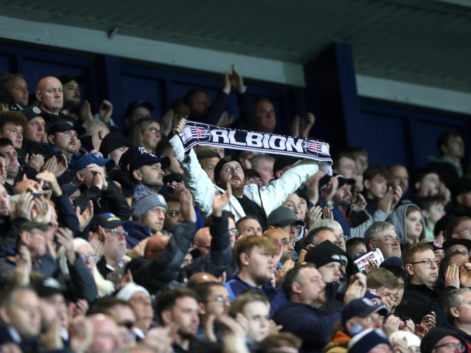 A general view of WBA fans at The Hawthorns with one holding up a scarf