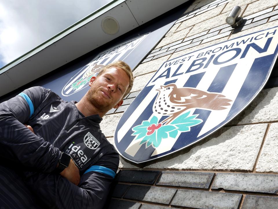 A photo of new U21 boss Leigh Downing in front of the Albion badge at the training ground