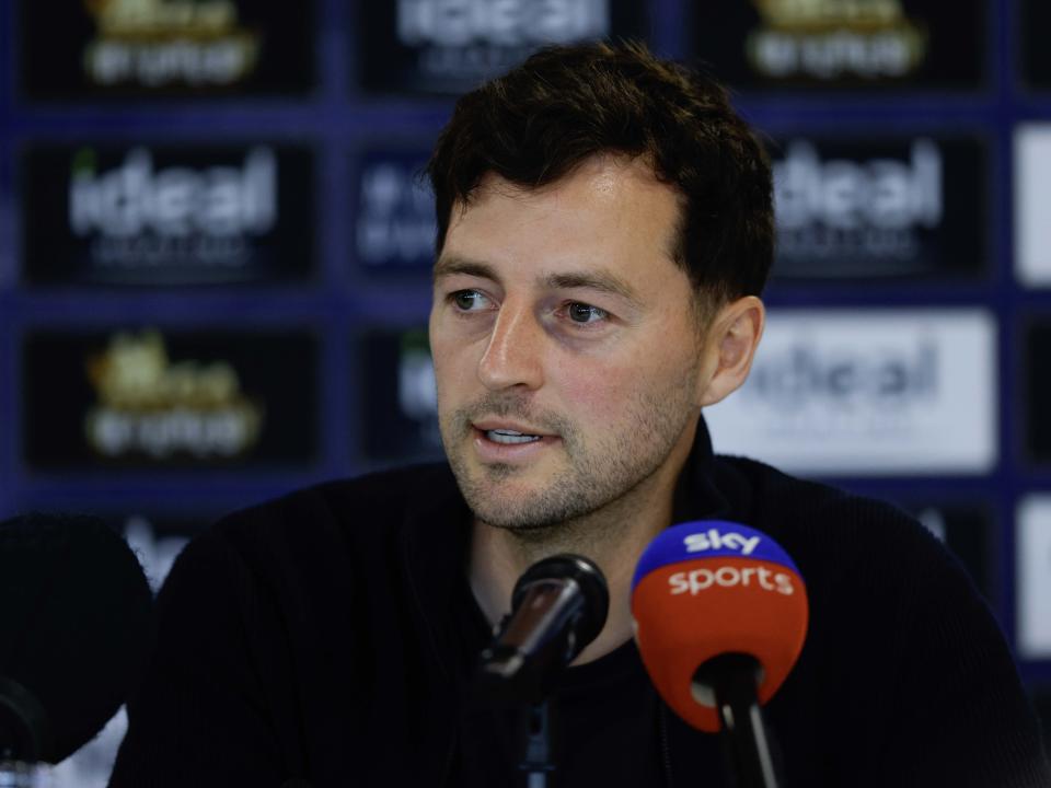 Ryan Mason being interviewed at a press conference with mics in front of him