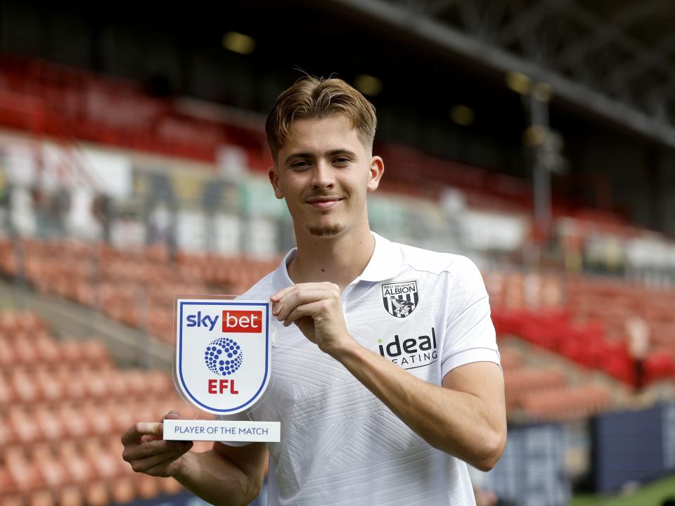 Isaac Price smiling at the camera with his Man of the Match trophy 