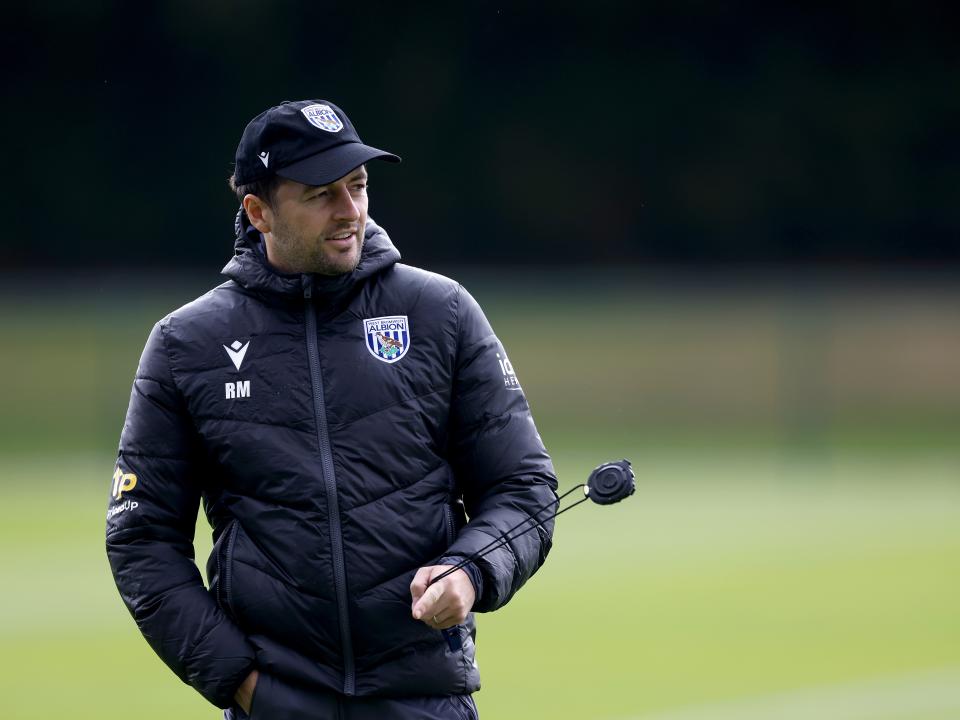 Ryan Mason with a cap on and a stopwatch in training