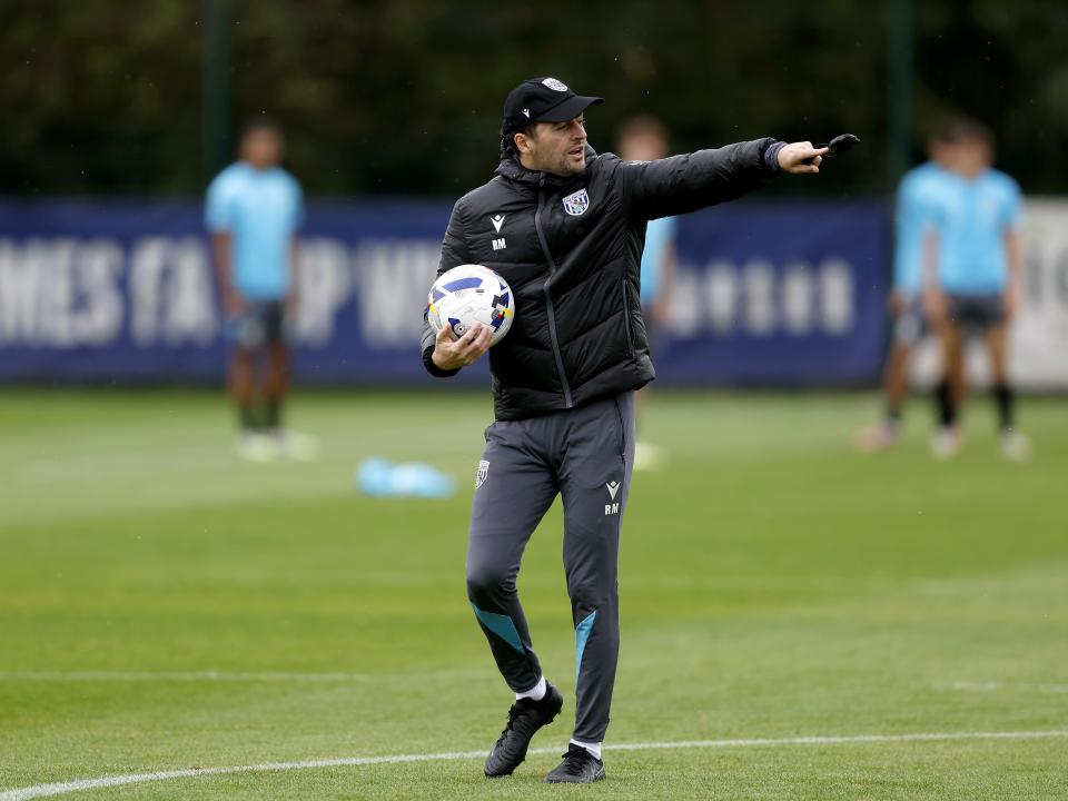 Ryan Mason with a cap on and a stopwatch in training