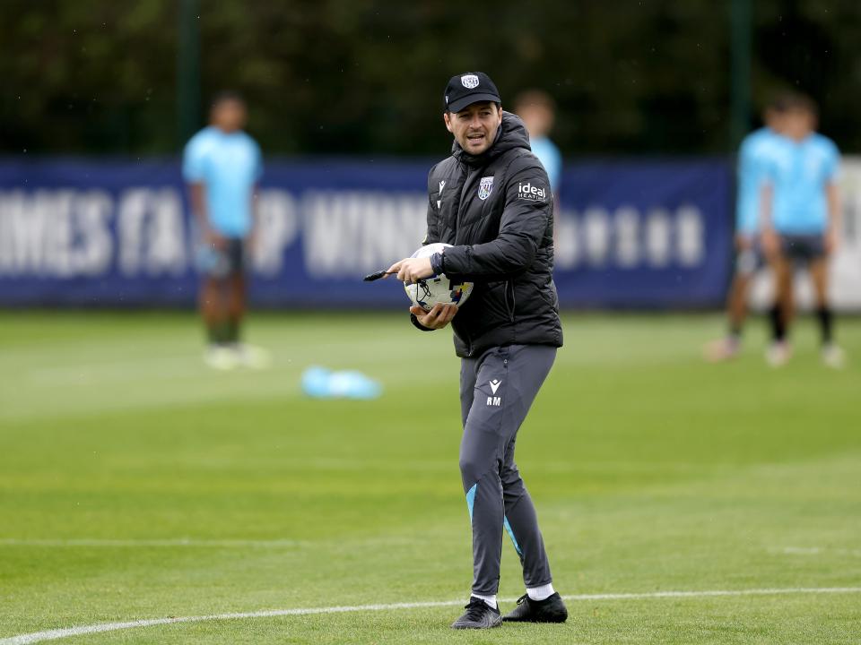 Ryan Mason with a cap on and a stopwatch in training