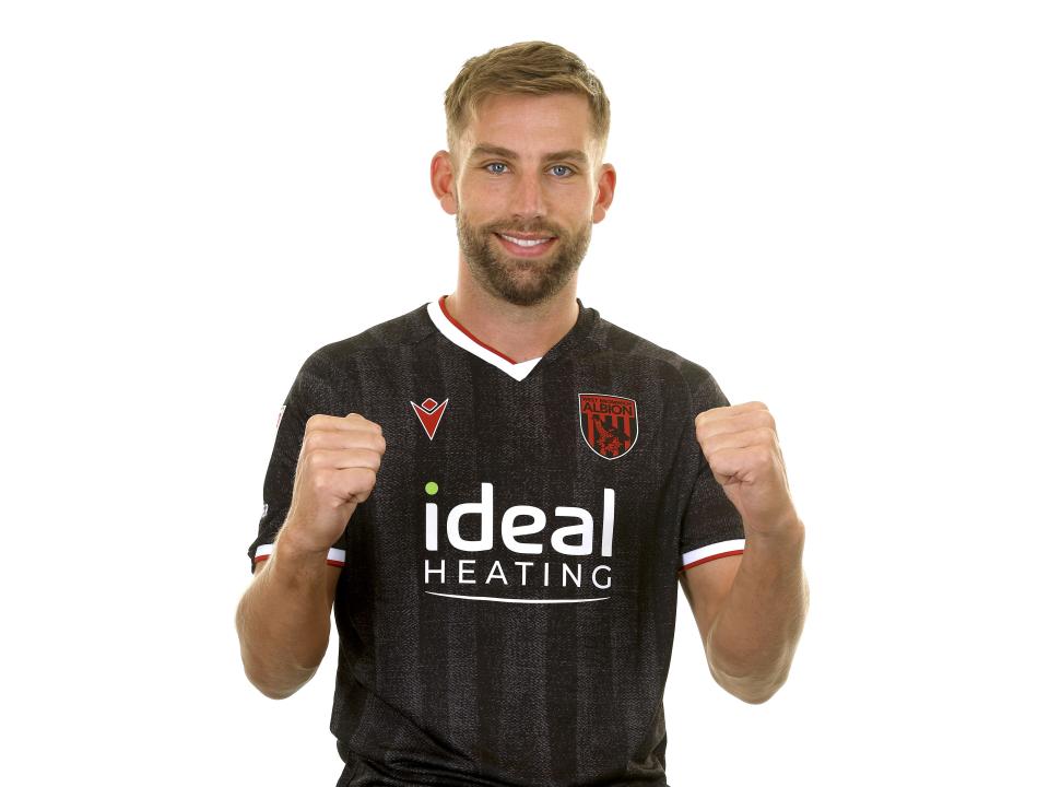 Charlie Taylor posing for a photo in the black away kit in front of a white background 