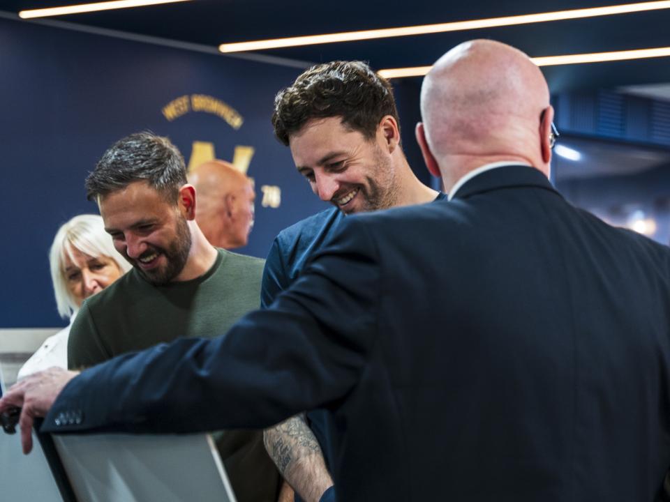 Ryan Mason smiling while viewing photos at The Hawthorns on the 125th anniversary of the stadium