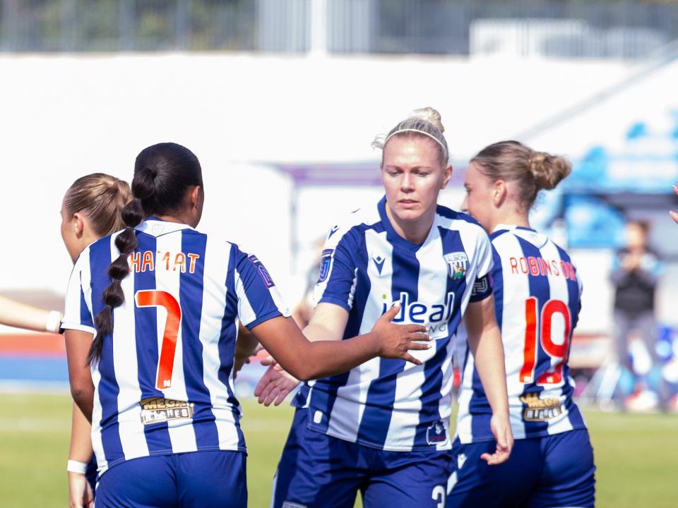 Hannah George celebrates with Simran Jhamat after a goal scored in the home kit