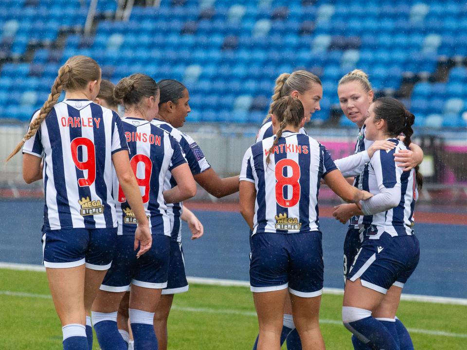 Several Albion Women players celebrate a goal in the home kit 