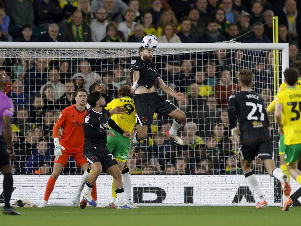 Nat Phillips jumping to head the ball against Norwich City