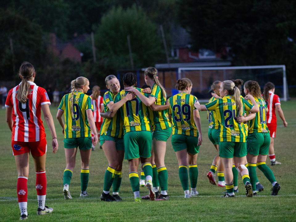A photo of our women's team celebrating a goal. 