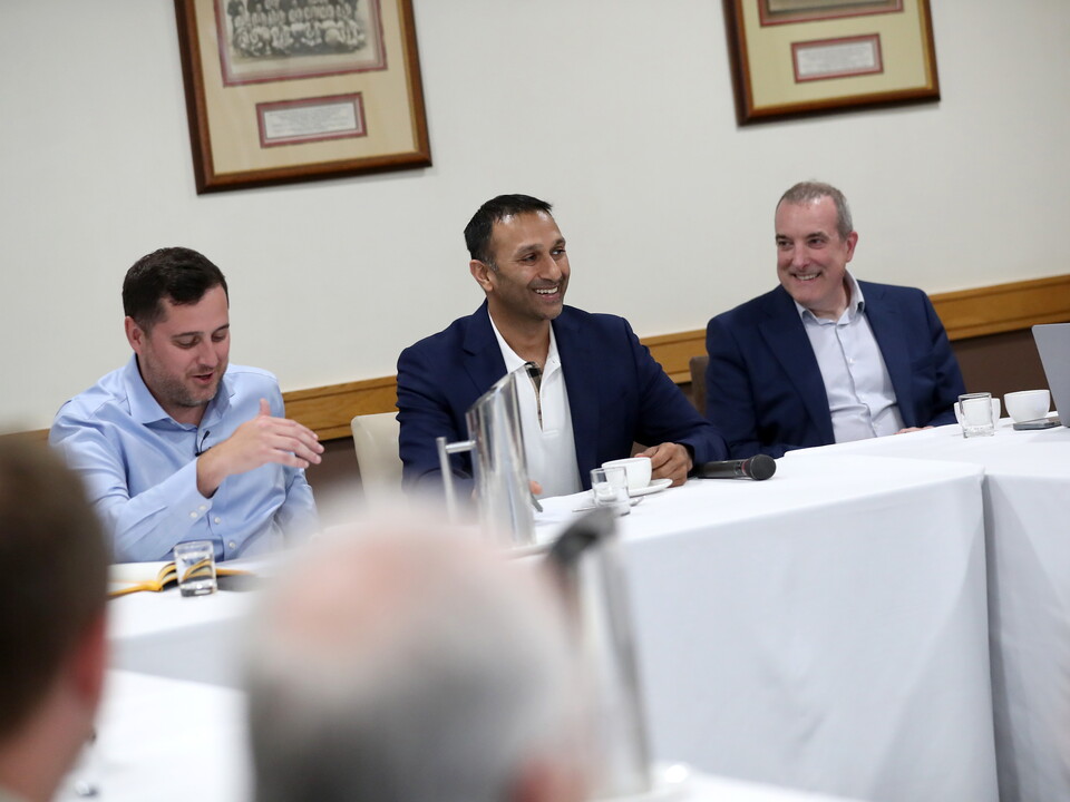 Shilen Patel smiling while sat at a table at a meeting 