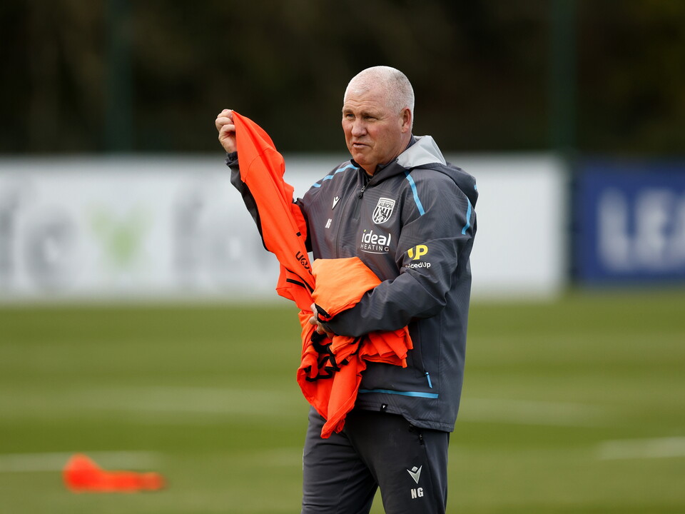 Nigel Gibbs handing out bibs during a training session