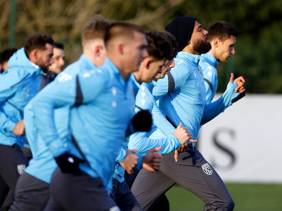 Several players warming up before a session, running forward in a line