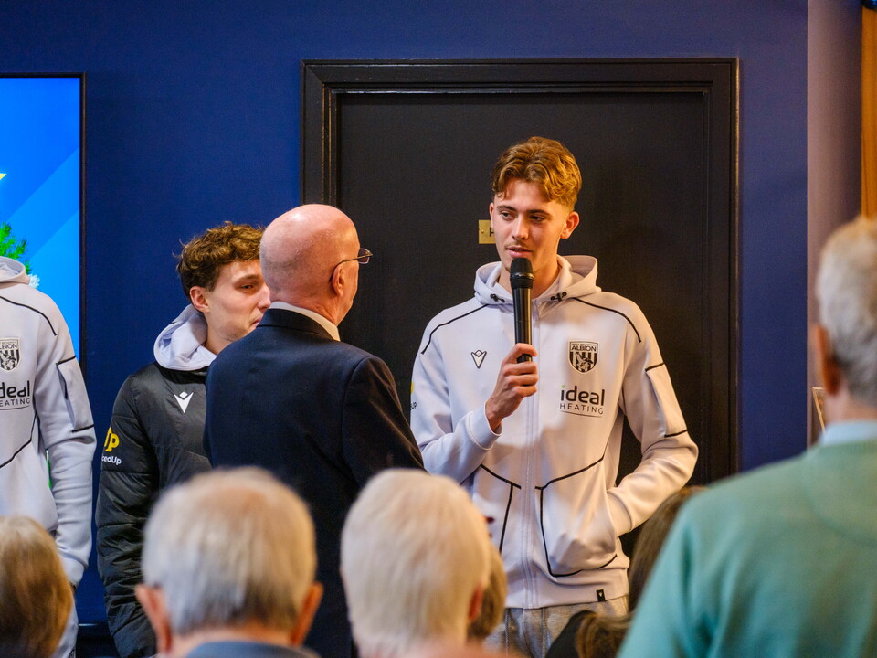 Issac Price speaking to the guests with Jon Homer.