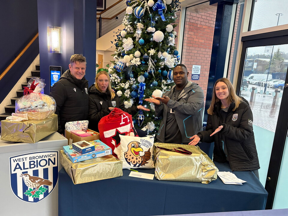 Foundation staff standing next to gifts for one of our families.