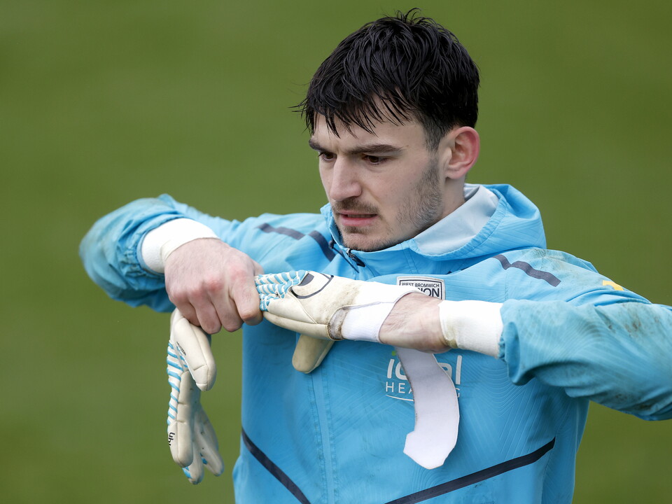 Max O'Leary pulling off his gloves in training