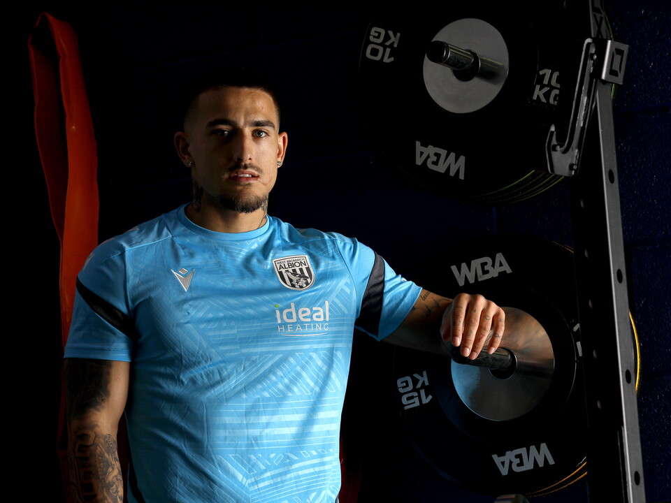 Danny Imray smiling at the camera while leaning against equipment in the gym
