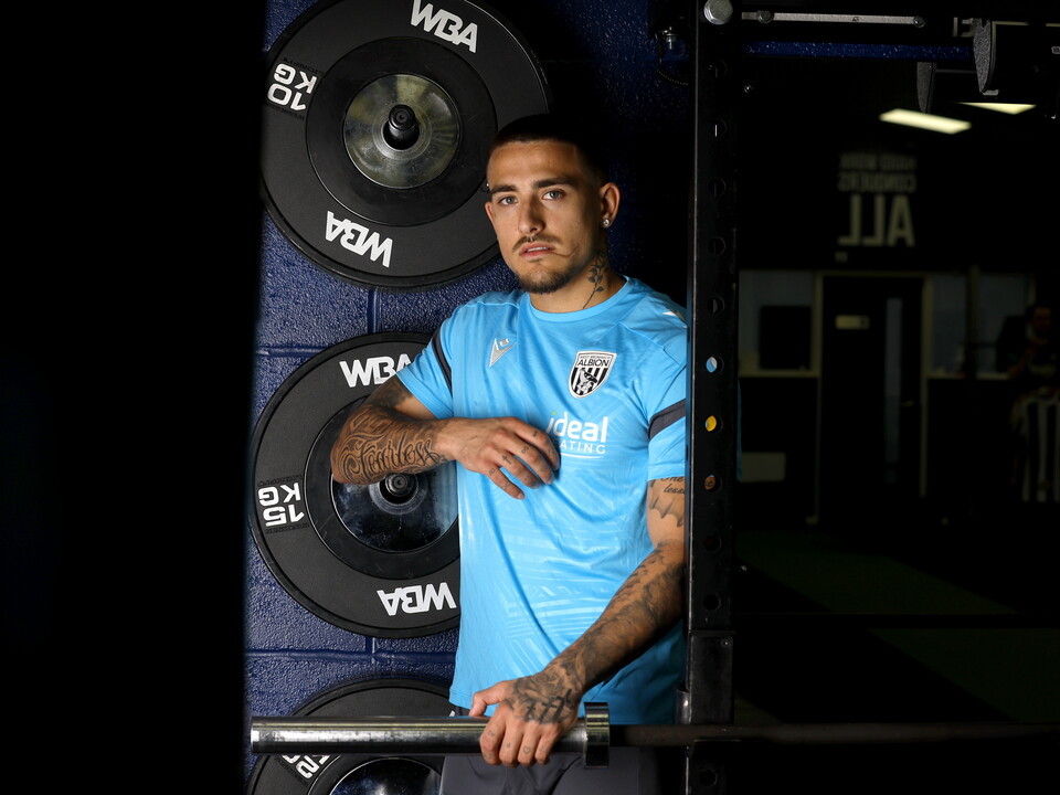 Danny Imray smiling at the camera while leaning against equipment in the gym