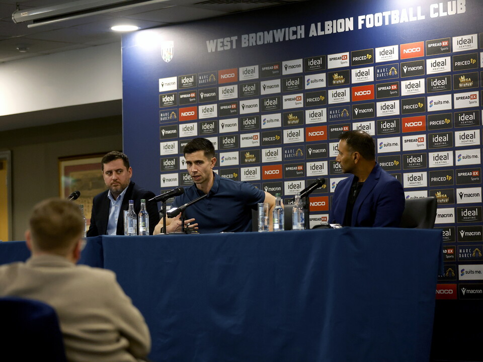 Eric Ramsay, Shilen Patel and Ian Skidmore sat up on stage on a press conference table 