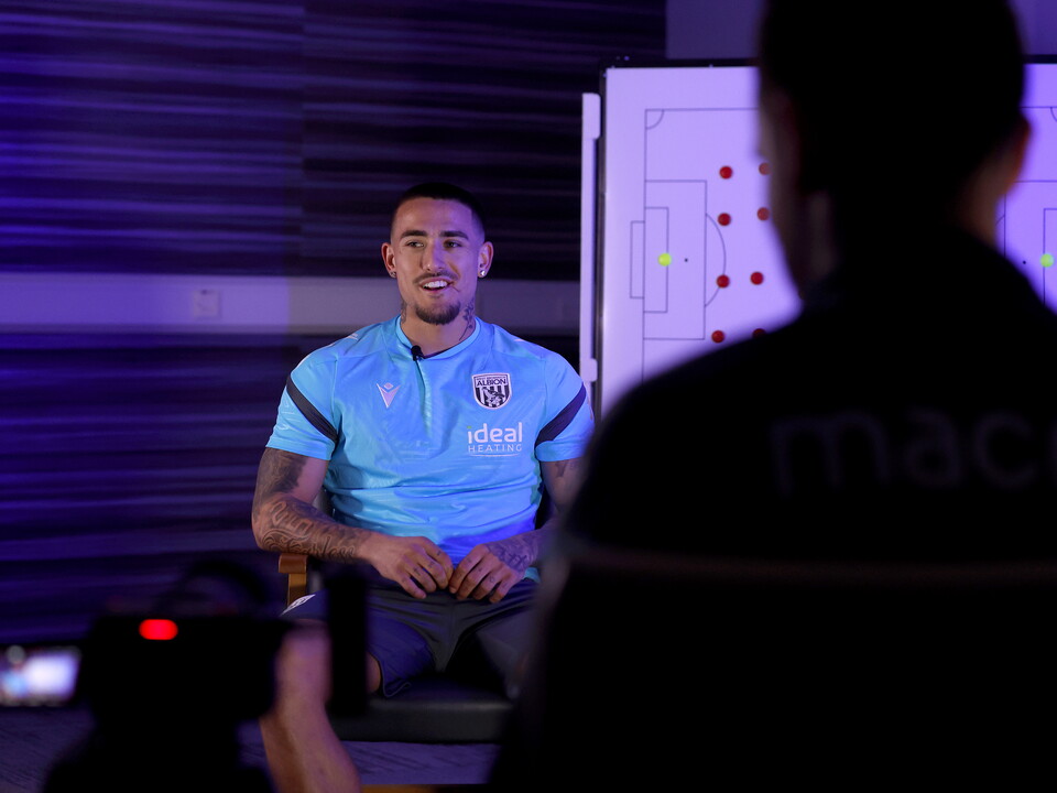 Danny Imray smiling while being interviewed by WBA TV while sat in front of a tactics board