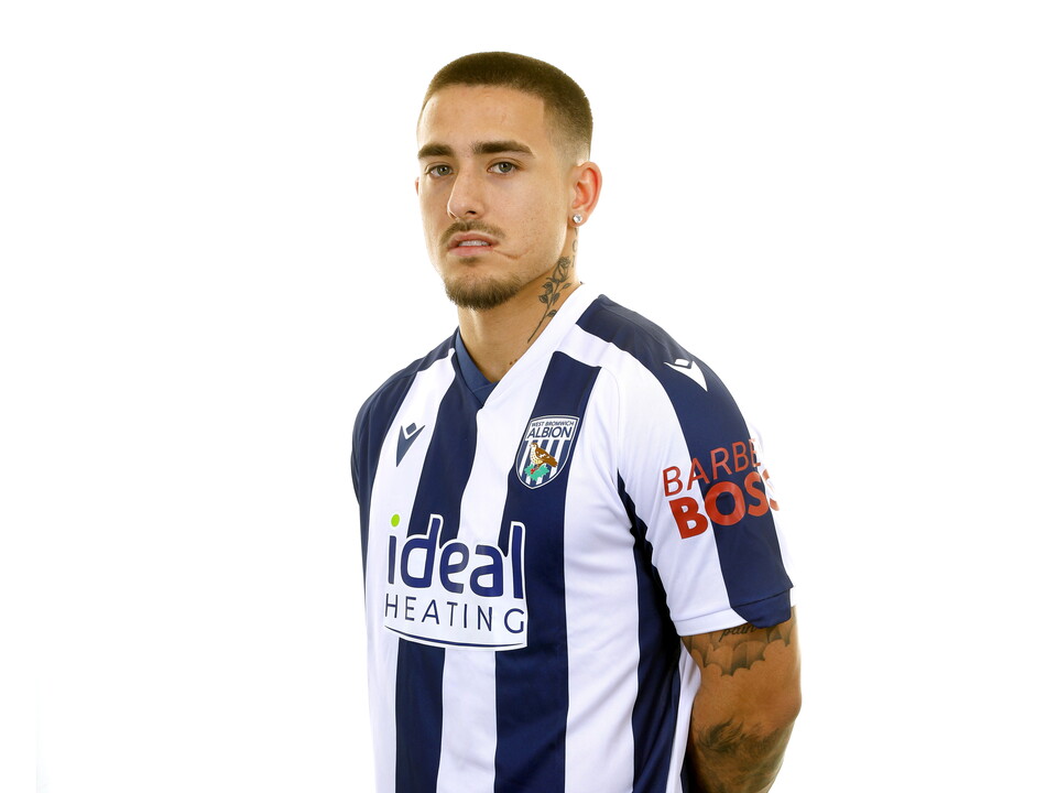 Danny Imray smiling at the camera while stood in front of a white background in a home WBA shirt