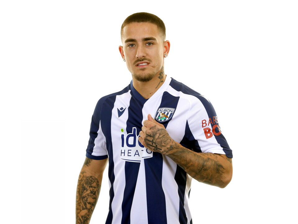 Danny Imray smiling at the camera while stood in front of a white background in a home WBA shirt
