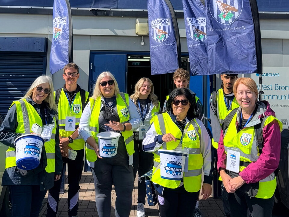 Baggies Bonanza volunteers holding buckets outside the WBA Community Sports Hall
