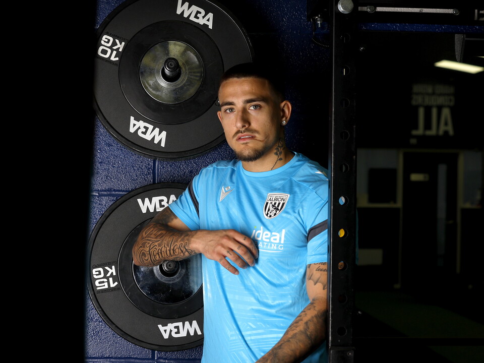Danny Imray smiling at the camera while leaning against equipment in the gym