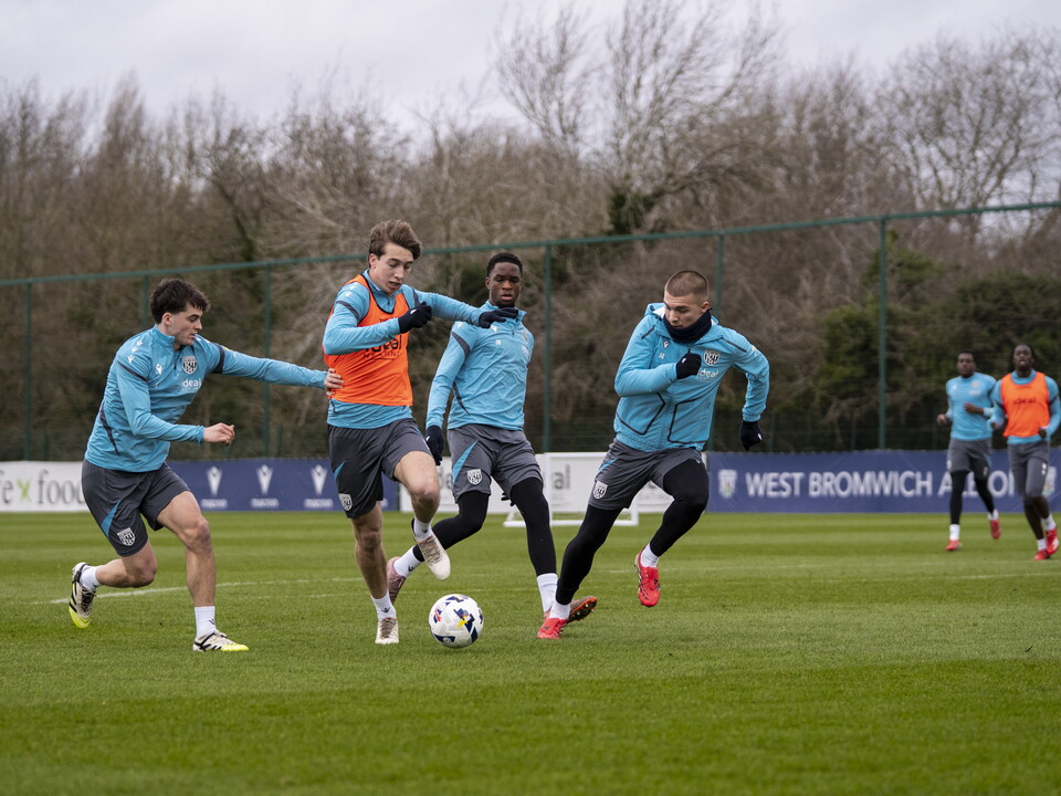Harry Whitwell running with the ball past three players during a training session