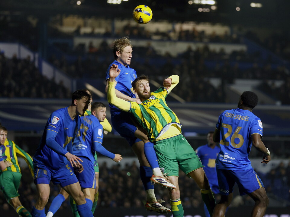 Nat Phillips jumps to try and win a header against a Blues defender 
