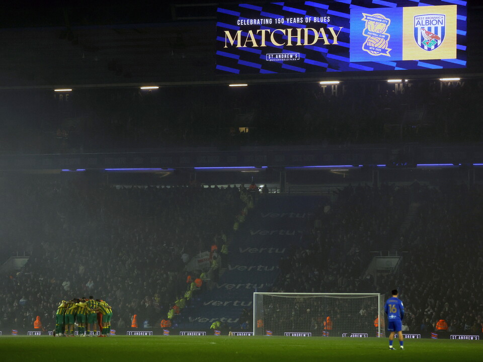 Albion players in a pre-match huddle in front of the away end at Birmingham