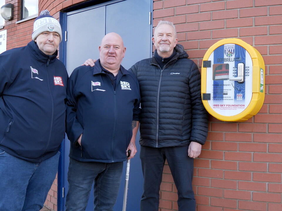 Richard Sant, Paul Gregory and Chris Harris pose next to a defibrillator