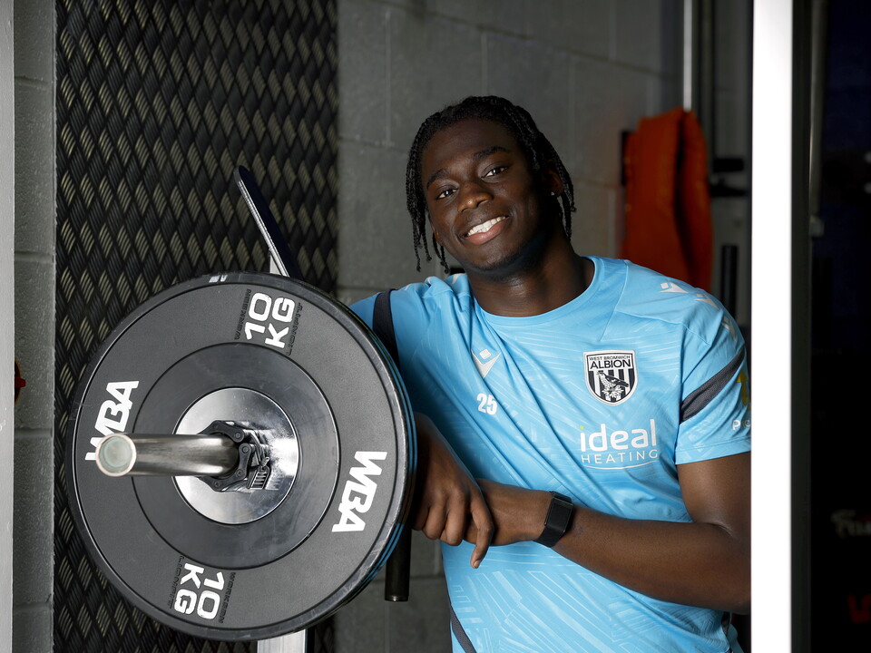 Hindolo Mustapha smiling at the camera while leaning in the gym
