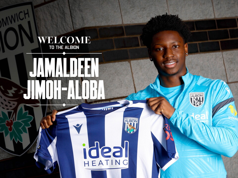 Jamaldeen Jimoh-Aloba smiling at the camera while holding a home shirt up with the words 'Welcome to the Albion Jamaldeen Jimoh-Aloba' written on