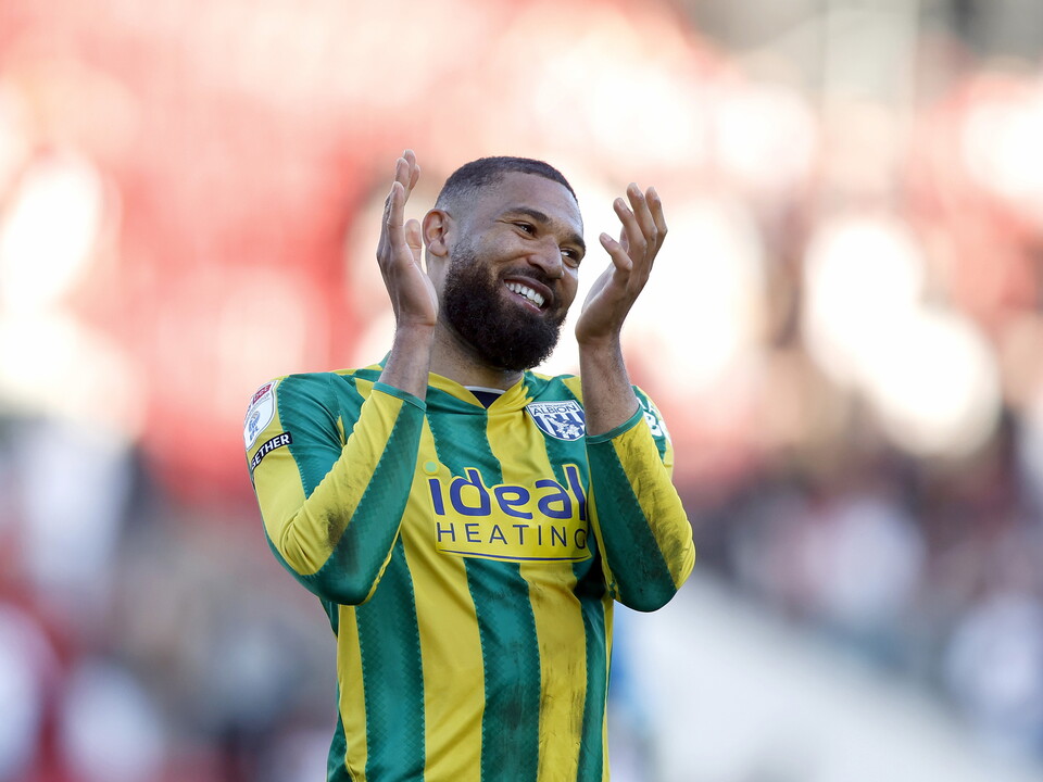 George Campbell applauding WBA fans in the green and yellow away kit 