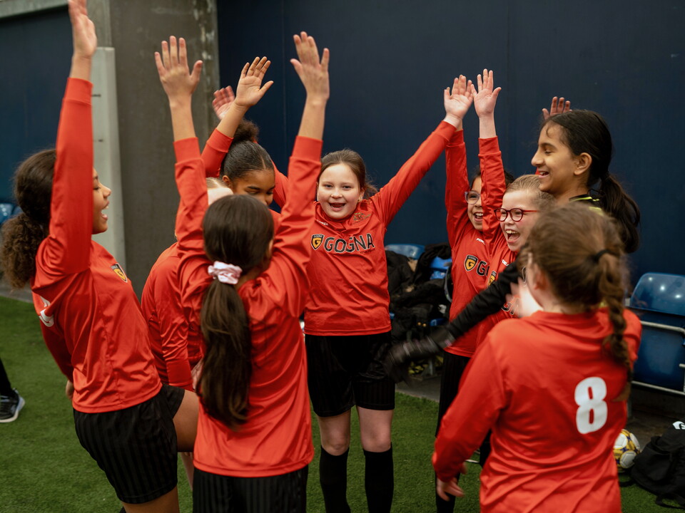 Players with arms raised after a team shout.